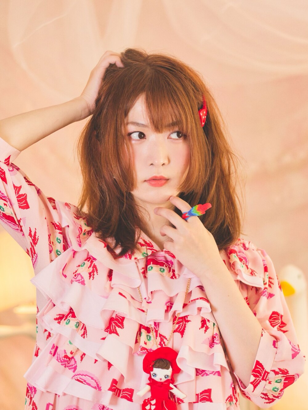 ピンク系のワンピース、グリーン系のイヤリングを着用したレディースの秋コーディネートの2枚目の写真