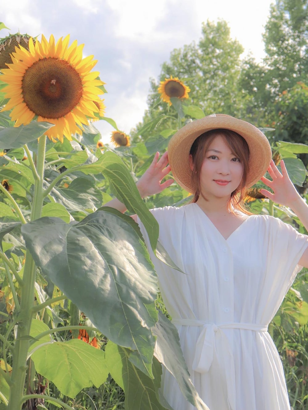 ホワイト系のワンピース、ホワイト系のサンダル、ベージュ系のハットを着用したレディースの夏コーディネートの2枚目の写真