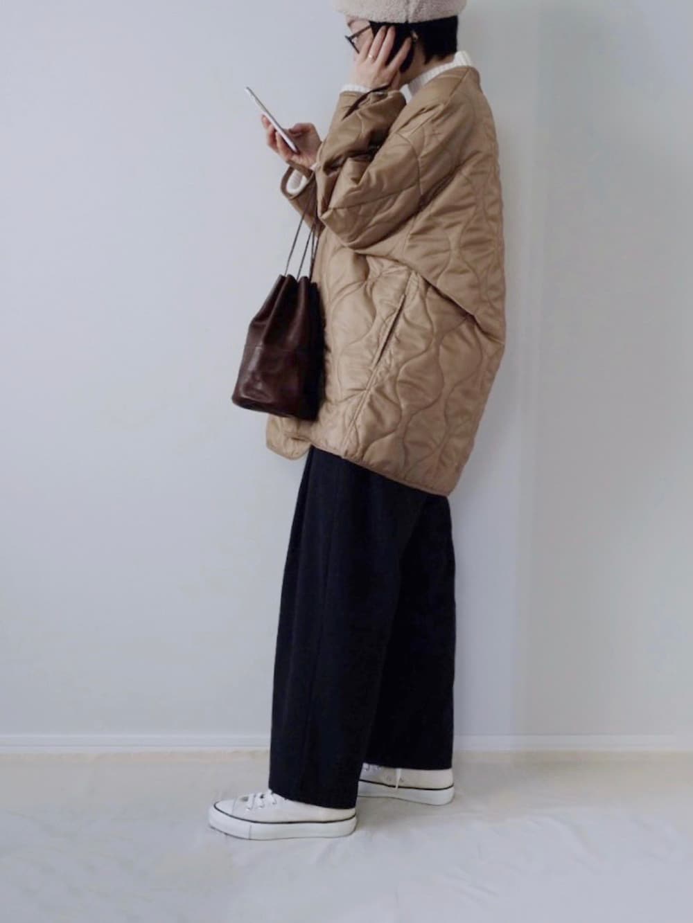 ホワイト系のスニーカー、ホワイト系のハットを着用したレディースの冬コーディネートの2枚目の写真