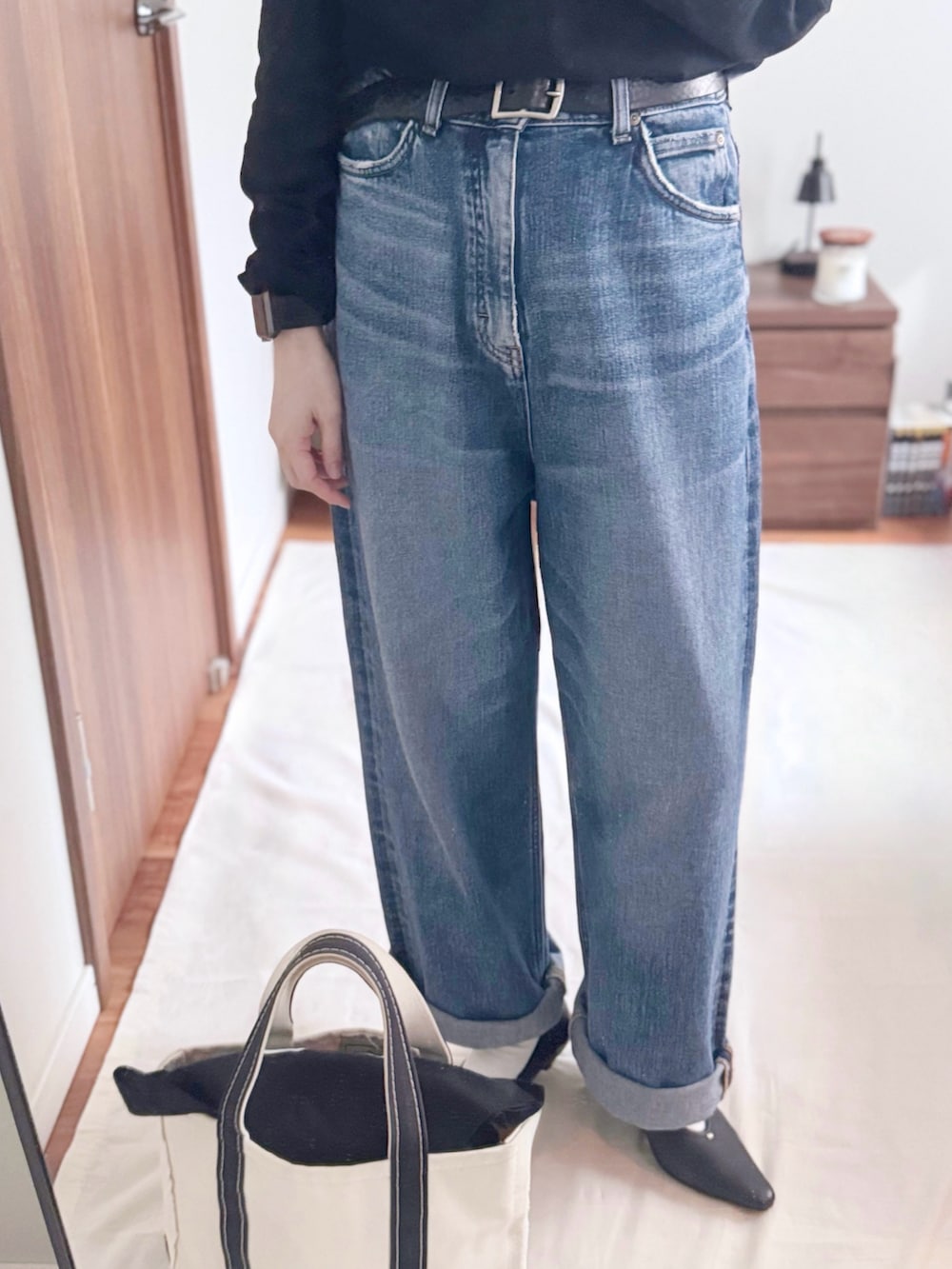 ブラック系のTシャツ/カットソー、ブルー系のデニムパンツ、ブラック系のパンプスを着用したレディースの秋コーディネートの4枚目の写真