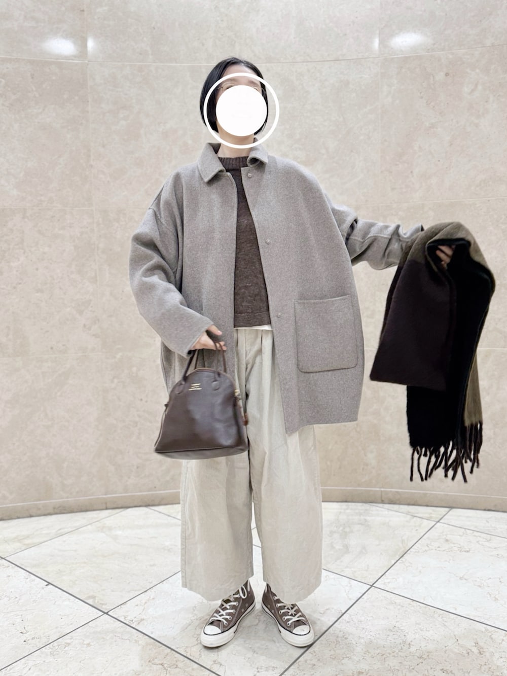 ブラウン系のスニーカー、ブラウン系のハンドバッグ、ブラウン系のニット/セーターを着用したレディースの冬コーディネートの2枚目の写真