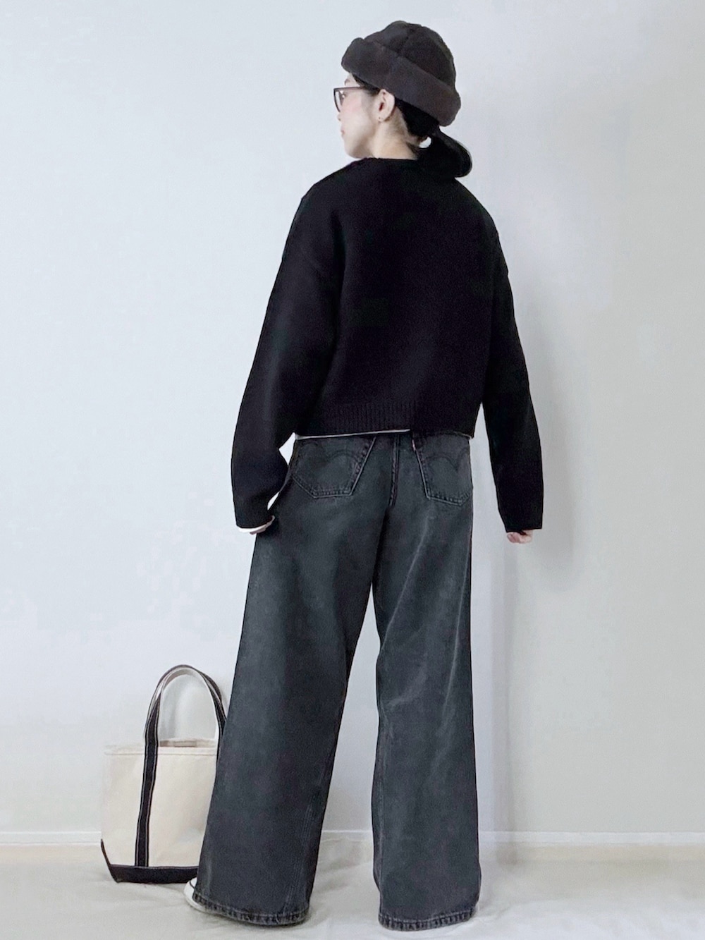 ブラック系のデニムパンツ、ブラック系のトートバッグ、グレー系のハットを着用したレディースの冬コーディネートの3枚目の写真