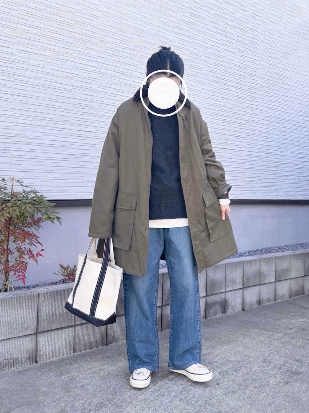 ホワイト系のTシャツ/カットソー、グレー系のニット/セーター、ブルー系のデニムパンツを着用したレディースの春コーディネートの2枚目の写真