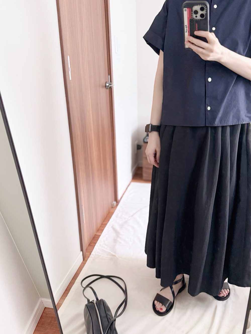 ブルー系のシャツ/ブラウス、ブラック系のスカート、ブラック系のショルダーバッグを着用したレディースの夏コーディネートの2枚目の写真