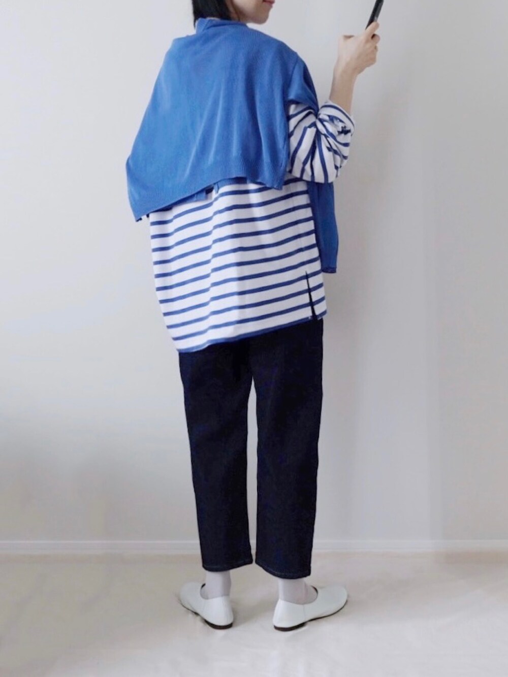 ブルー系のデニムパンツ、ホワイト系のパンプスを着用したレディースの春コーディネートの2枚目の写真