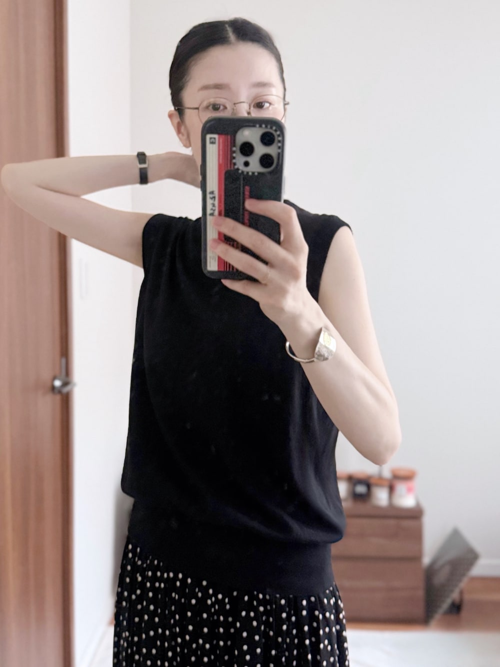 ブラック系のニット/セーター、ブラック系のスカート、ブラック系のボストンバッグを着用したレディースの夏コーディネートの3枚目の写真