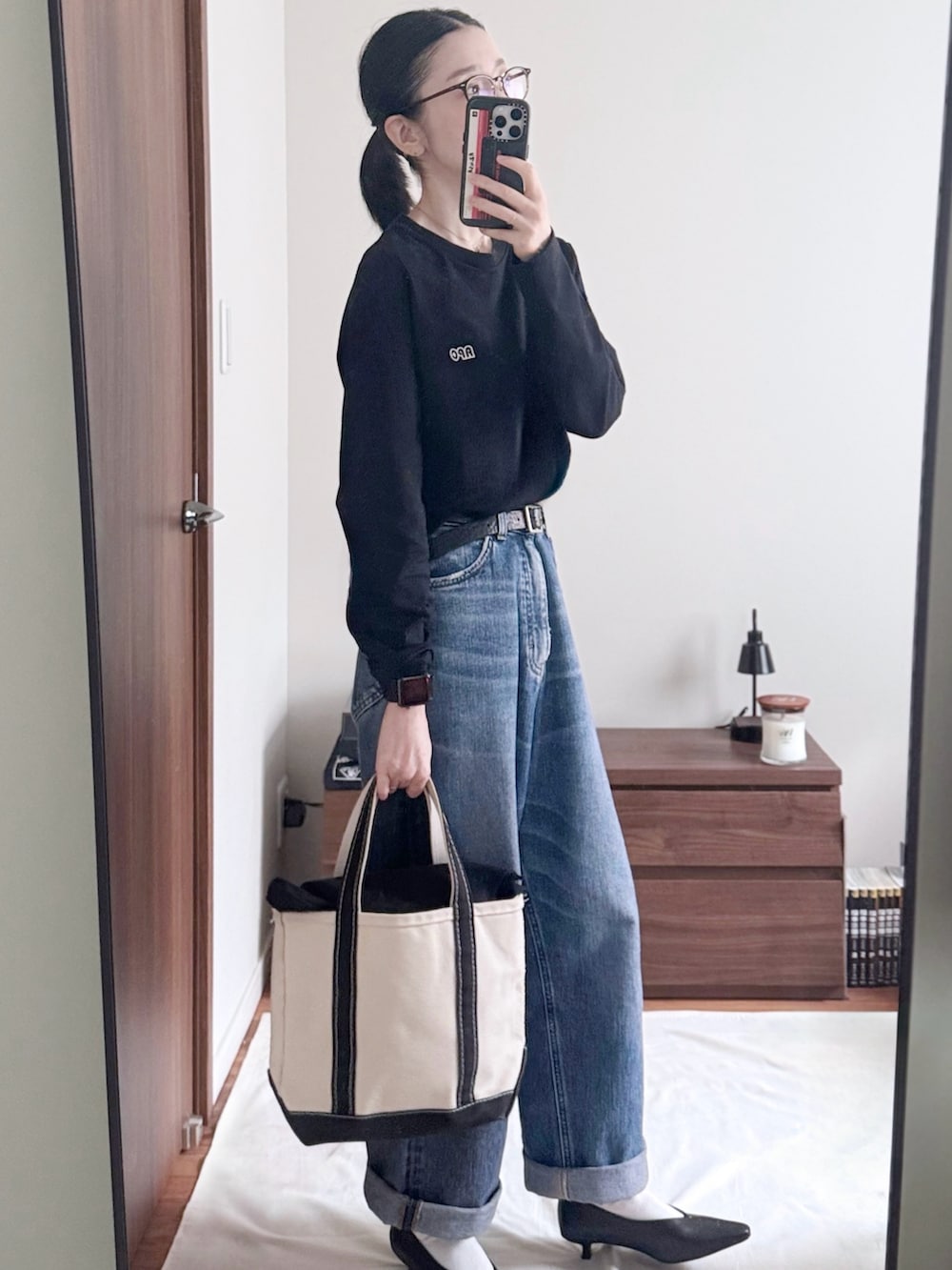 ブラック系のTシャツ/カットソー、ブルー系のデニムパンツ、ブラック系のパンプスを着用したレディースの秋コーディネートの2枚目の写真