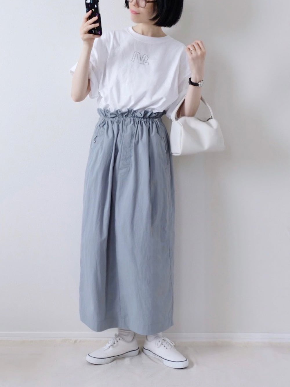 ホワイト系のTシャツ/カットソー、グレー系のスカート、ホワイト系のスニーカーを着用したレディースの春コーディネートの2枚目の写真