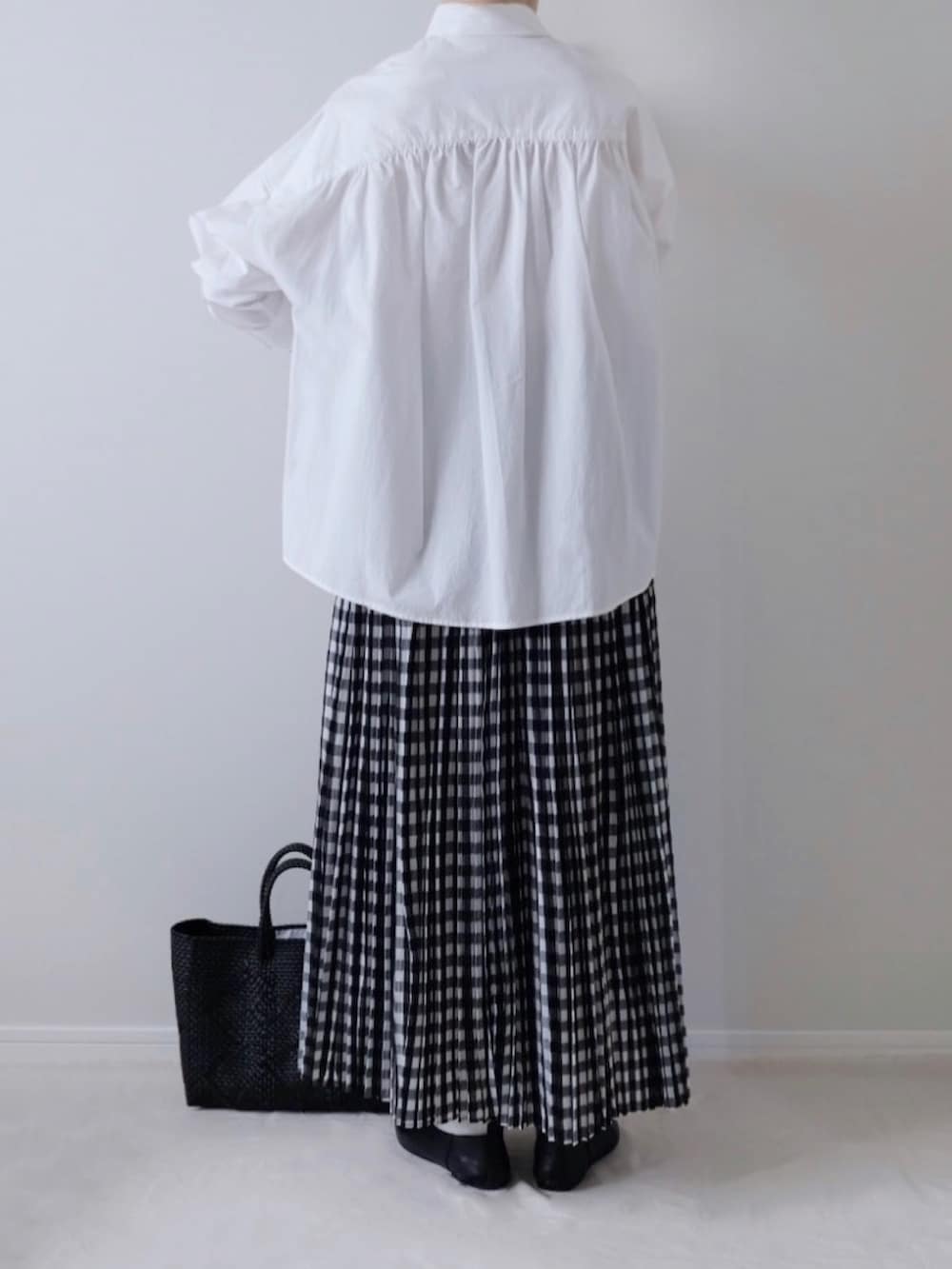 ホワイト系のシャツ/ブラウス、ブラック系のその他シューズ、ブラック系のかごバッグを着用したレディースの秋コーディネートの2枚目の写真