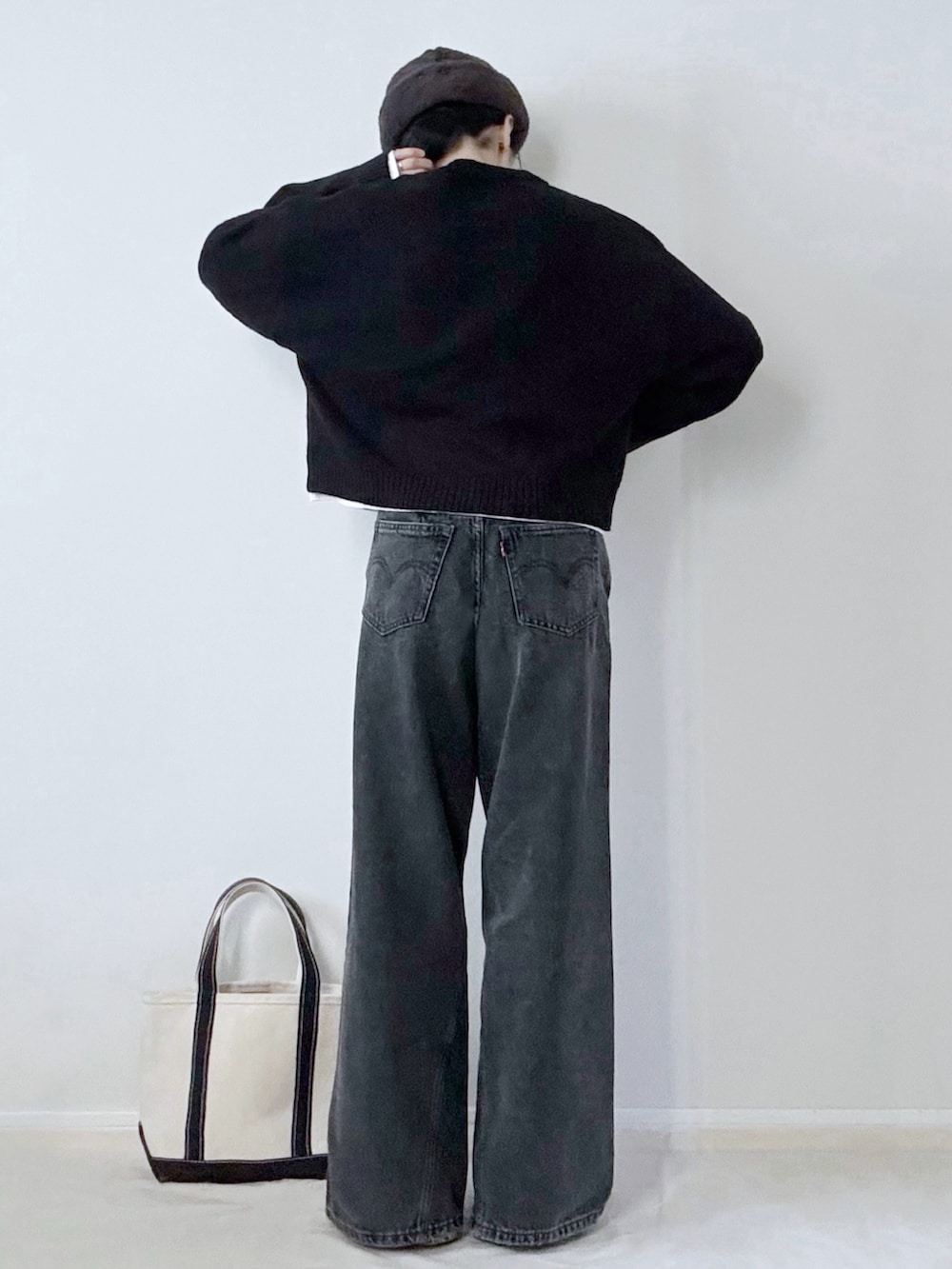 ブラック系のデニムパンツ、ブラック系のトートバッグ、グレー系のハットを着用したレディースの冬コーディネートの4枚目の写真