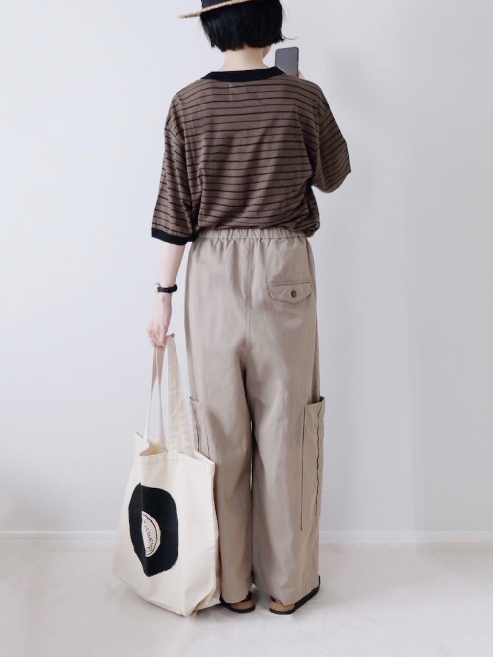 グリーン系のTシャツ/カットソー、ベージュ系のカーゴパンツ、ブラック系のサンダルを着用したレディースの夏コーディネートの2枚目の写真