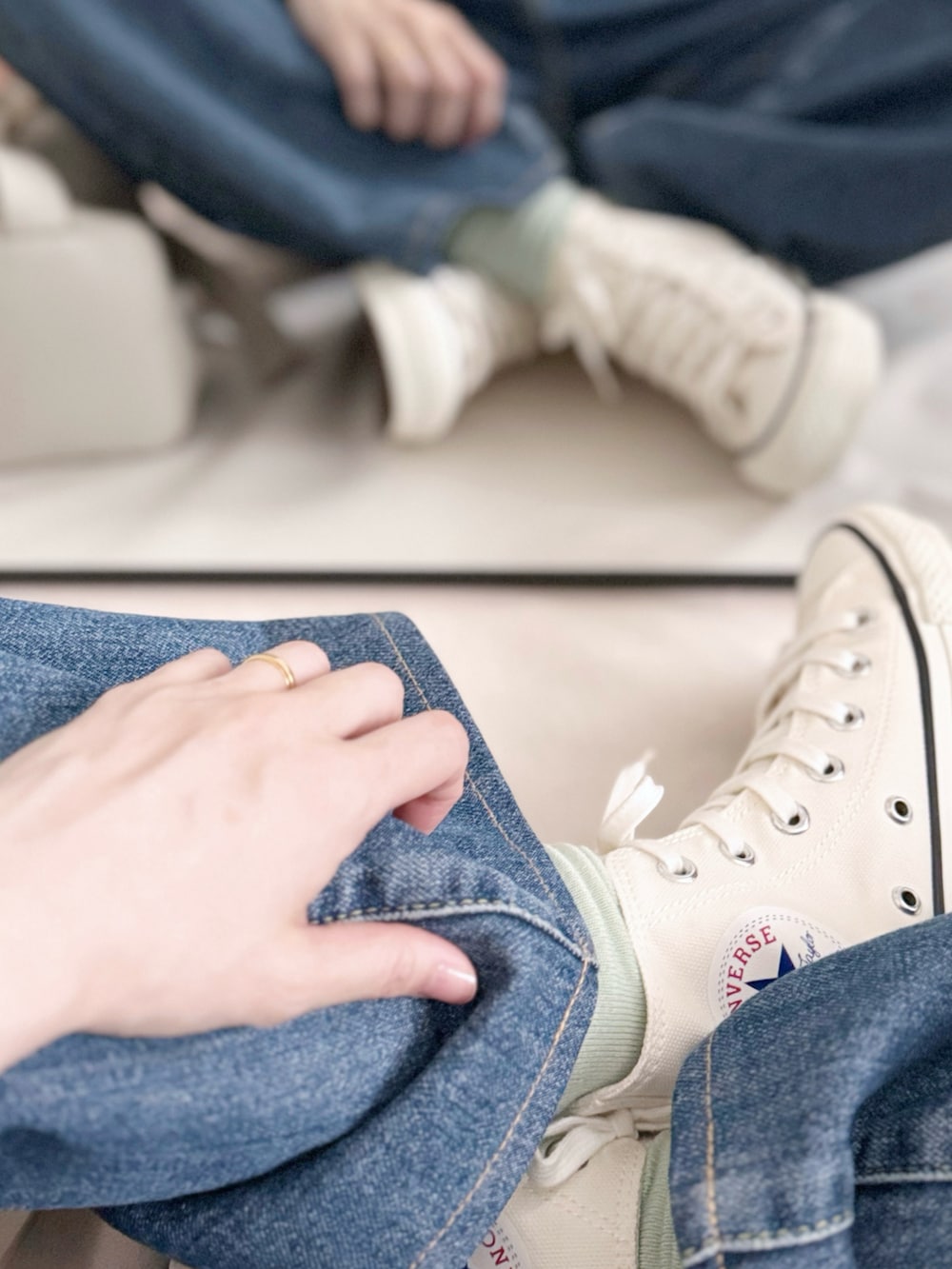 ホワイト系のスニーカー、ブルー系のデニムパンツ、ホワイト系のショルダーバッグを着用したレディースの夏コーディネートの5枚目の写真