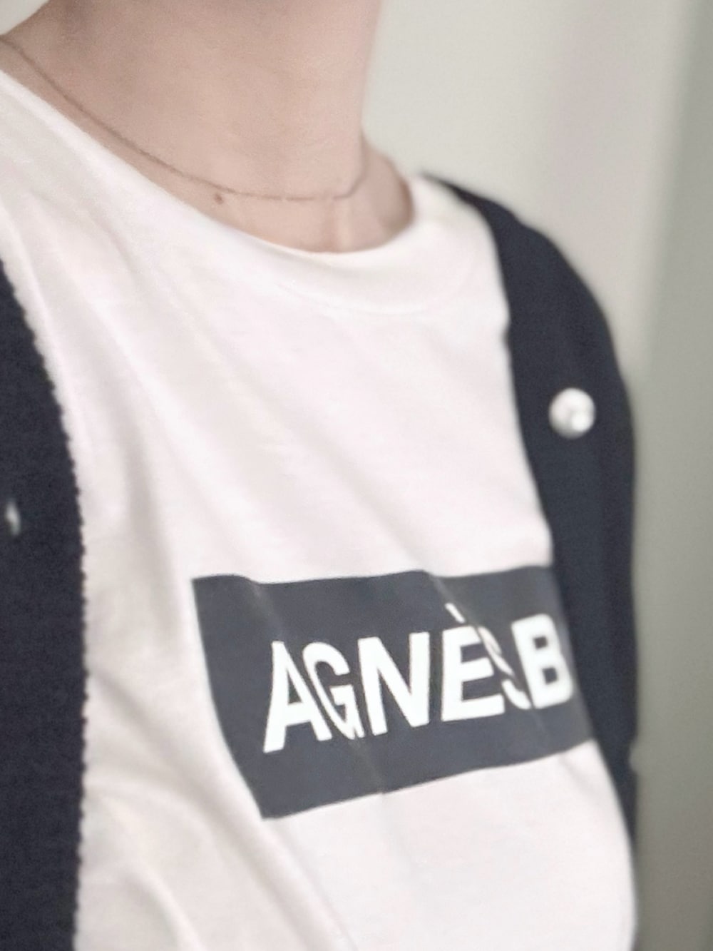 ホワイト系のTシャツ/カットソー、ブラック系のショルダーバッグ、ブラック系のカーディガン/ボレロを着用したレディースの秋コーディネートの3枚目の写真