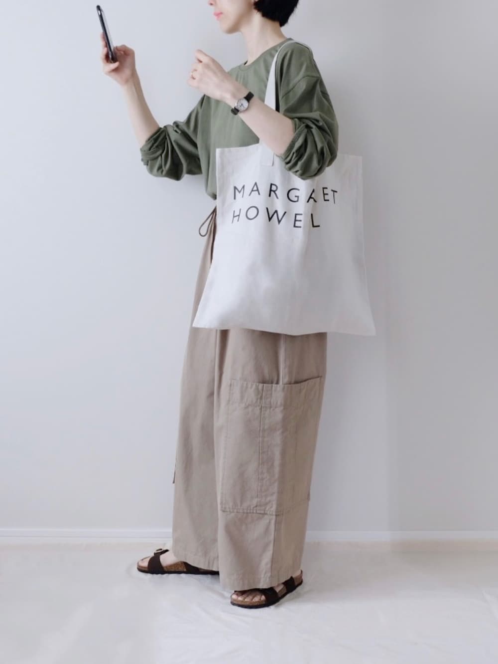 ベージュ系のカーゴパンツ、グレー系のトートバッグを着用したレディースの夏コーディネートの2枚目の写真