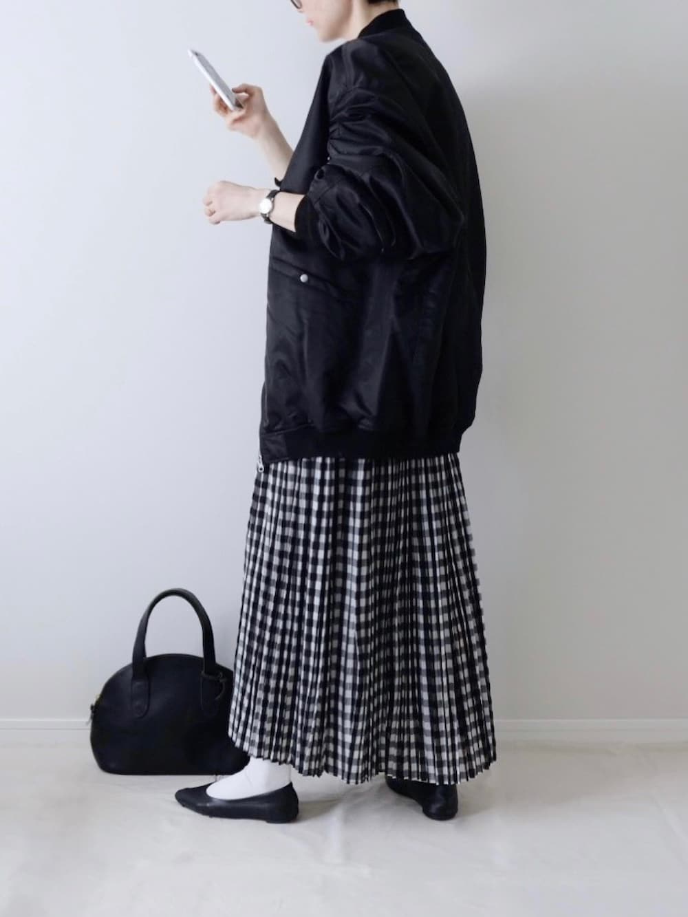 ブラック系のボストンバッグを着用したレディースの秋コーディネートの2枚目の写真