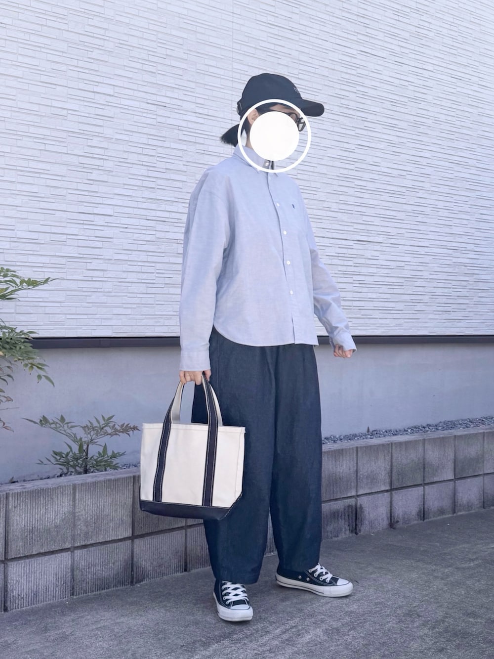 ブラック系のトートバッグ、ブルー系のシャツ/ブラウス、ブルー系のデニムパンツを着用したレディースの春コーディネートの2枚目の写真