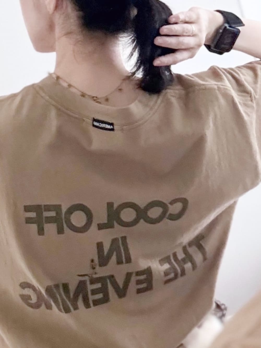 ブラック系のボストンバッグ、ブラウン系のサンダル、ベージュ系のTシャツ/カットソーを着用したレディースの夏コーディネートの3枚目の写真
