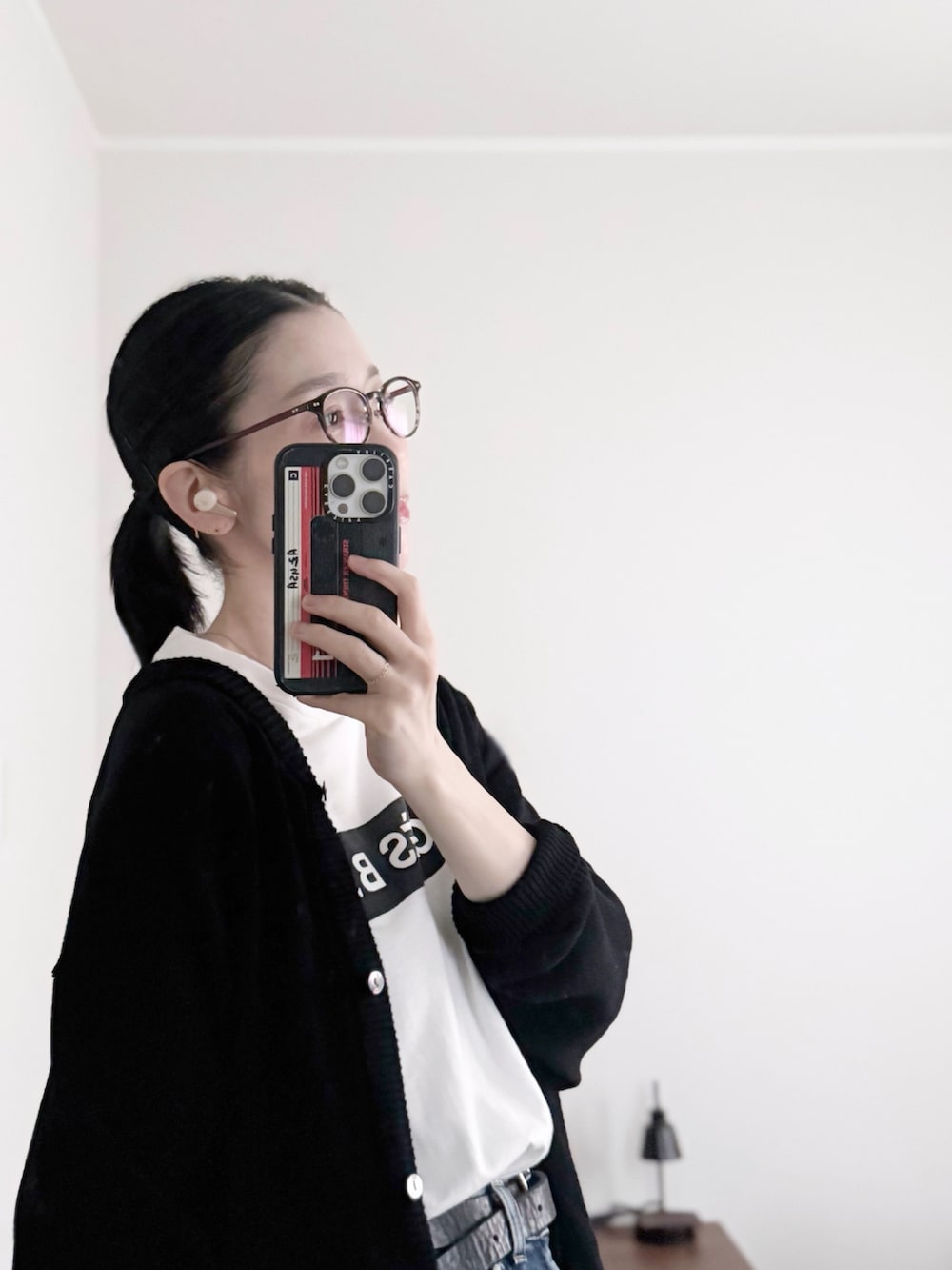 ホワイト系のTシャツ/カットソー、ブラック系のショルダーバッグ、ブラック系のカーディガン/ボレロを着用したレディースの秋コーディネートの2枚目の写真