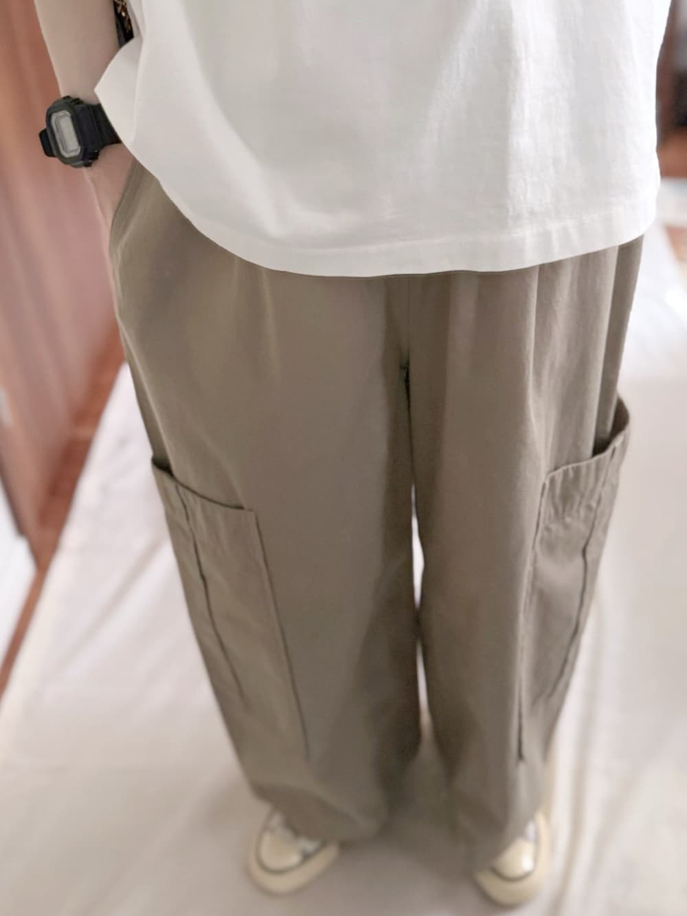 ブラック系のボストンバッグ、ホワイト系のTシャツ/カットソー、ベージュ系のカーゴパンツを着用したレディースの夏コーディネートの2枚目の写真