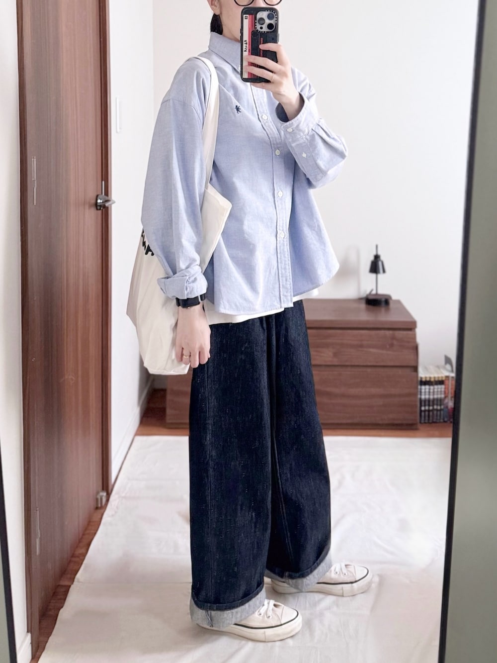 ブルー系のシャツ/ブラウス、ブルー系のデニムパンツ、ホワイト系のトートバッグを着用したレディースの秋コーディネートの2枚目の写真