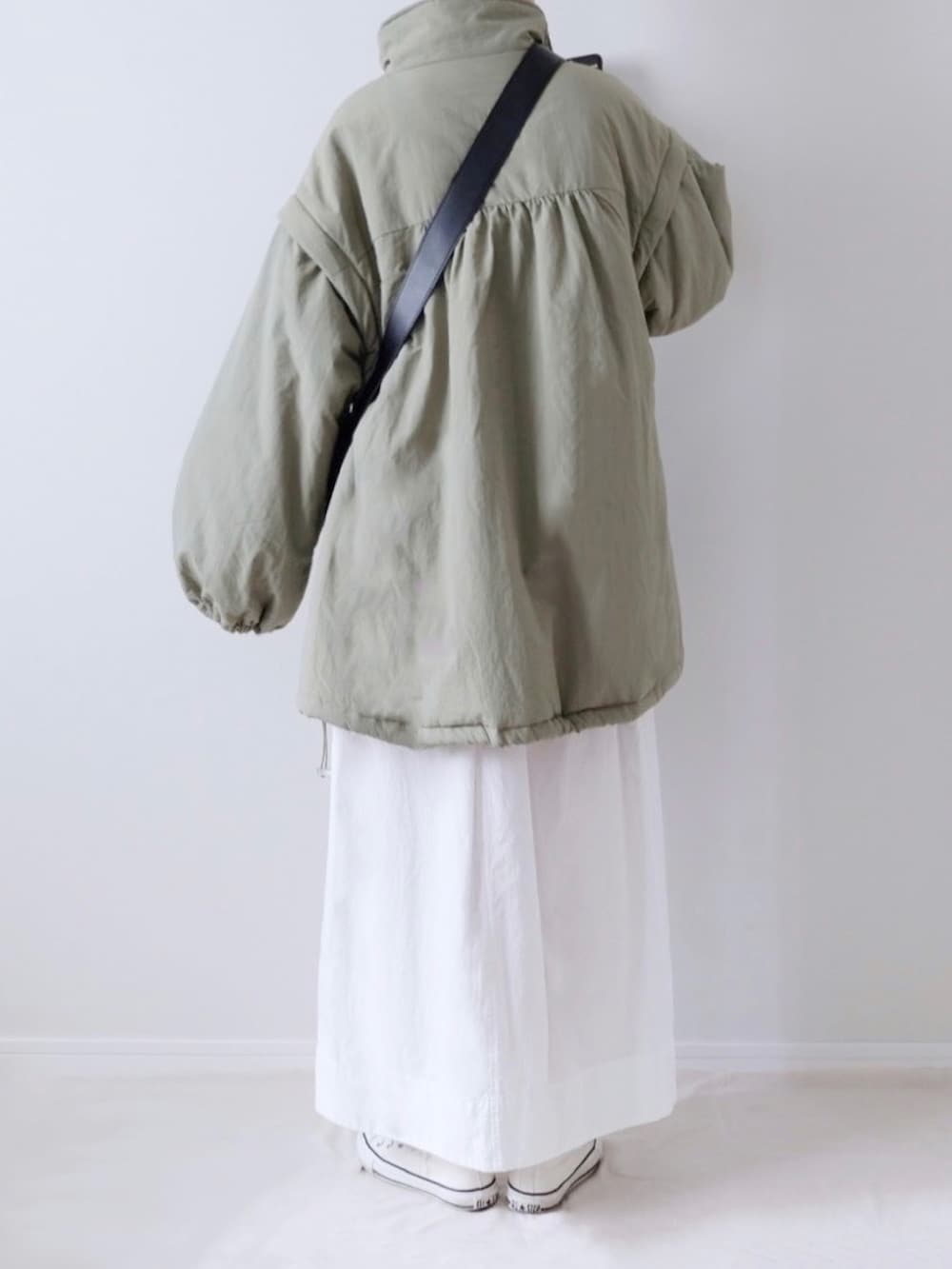 ブラック系のTシャツ/カットソー、ホワイト系のスカート、ホワイト系のスニーカーを着用したレディースの秋コーディネートの5枚目の写真