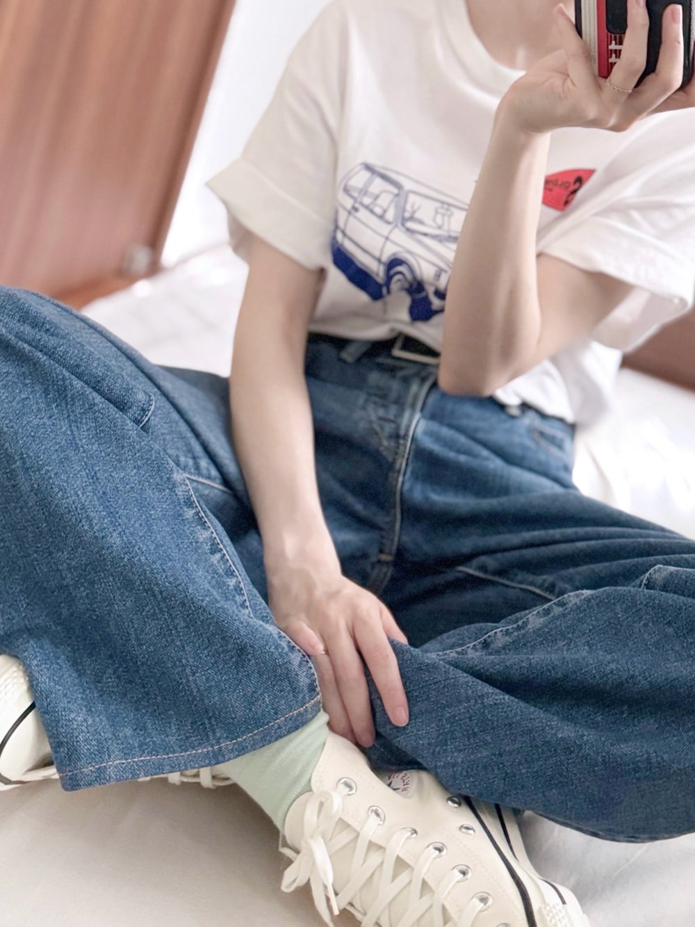 ホワイト系のスニーカー、ブルー系のデニムパンツ、ホワイト系のショルダーバッグを着用したレディースの夏コーディネートの4枚目の写真