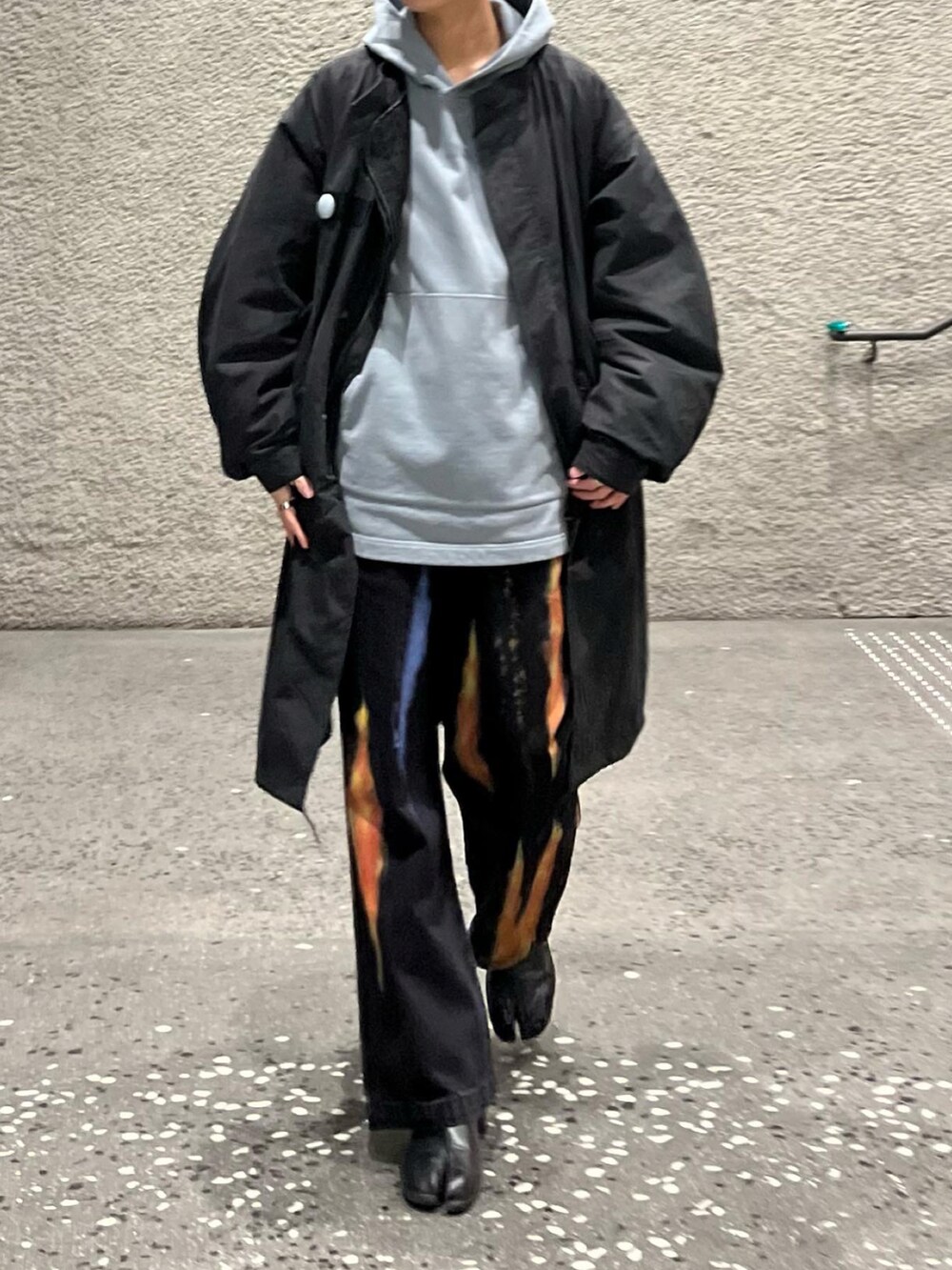 グレー系のパーカー、ブラック系のデニムパンツ、ブラック系のブーツを着用したメンズの冬コーディネートの2枚目の写真