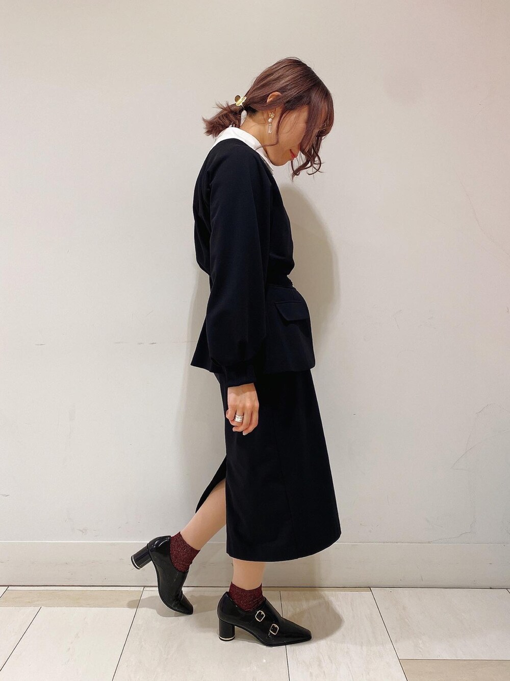 ブラック系のTシャツ/カットソー、ブラック系のスカート、ブラック系のブーティを着用したレディースの春コーディネートの2枚目の写真