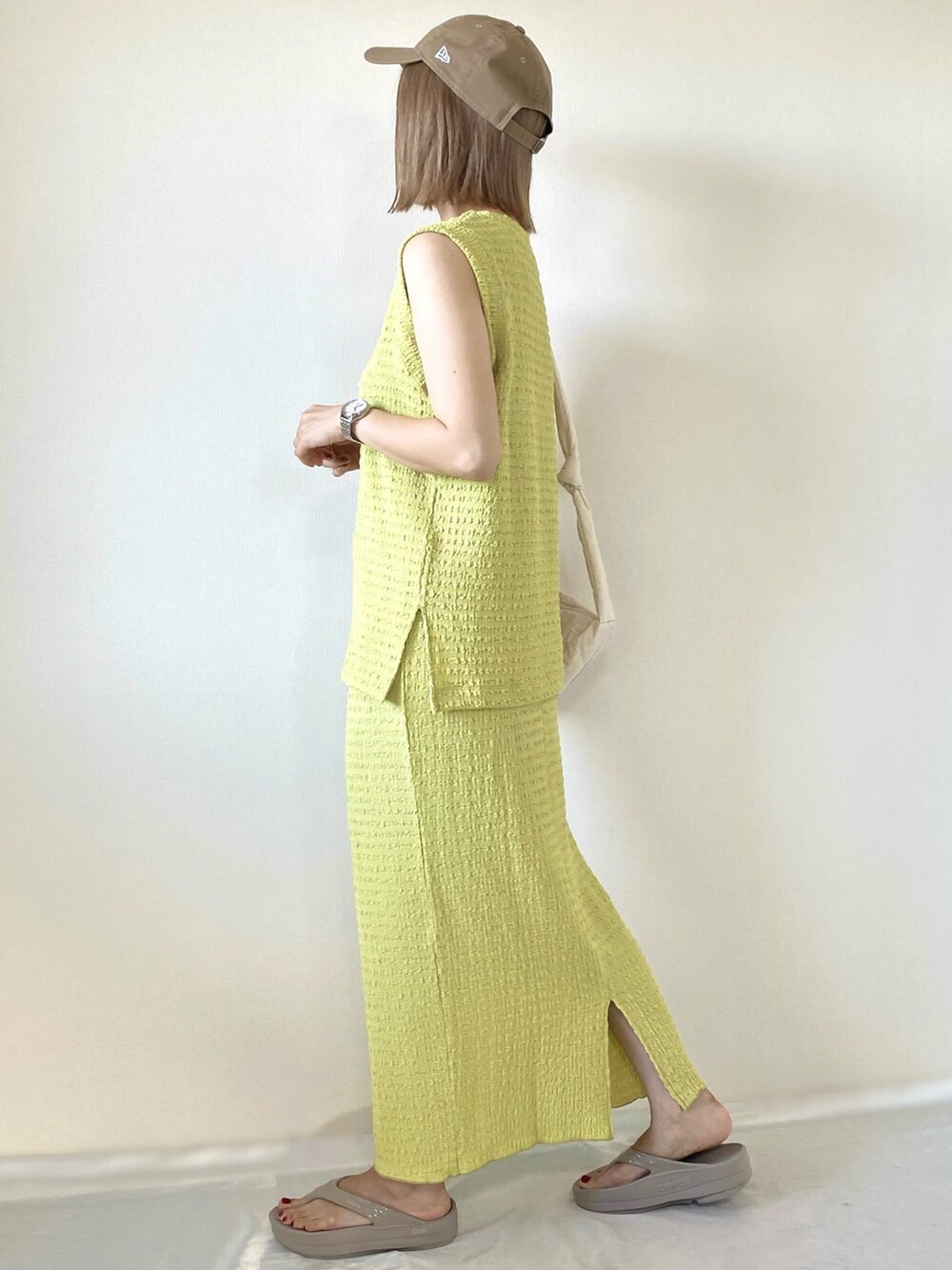 グリーン系のスカート、グリーン系のTシャツ/カットソー、ベージュ系のサンダルを着用したレディースの春コーディネートの2枚目の写真