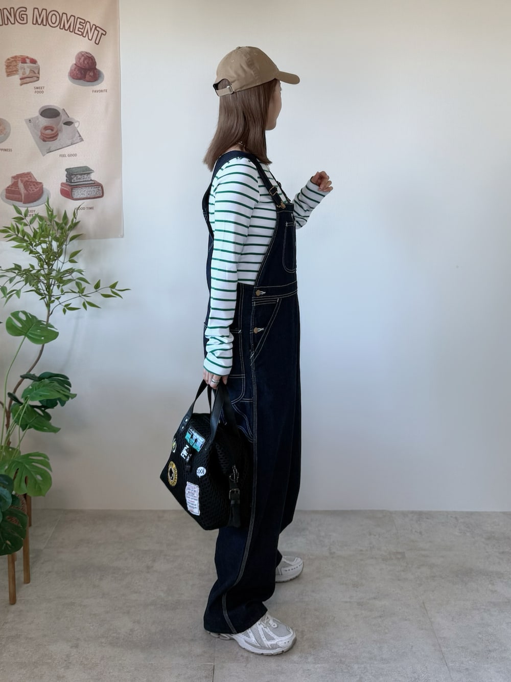 ホワイト系のスニーカー、ブラック系のボストンバッグ、グリーン系のTシャツ/カットソーを着用したレディースの冬コーディネートの3枚目の写真