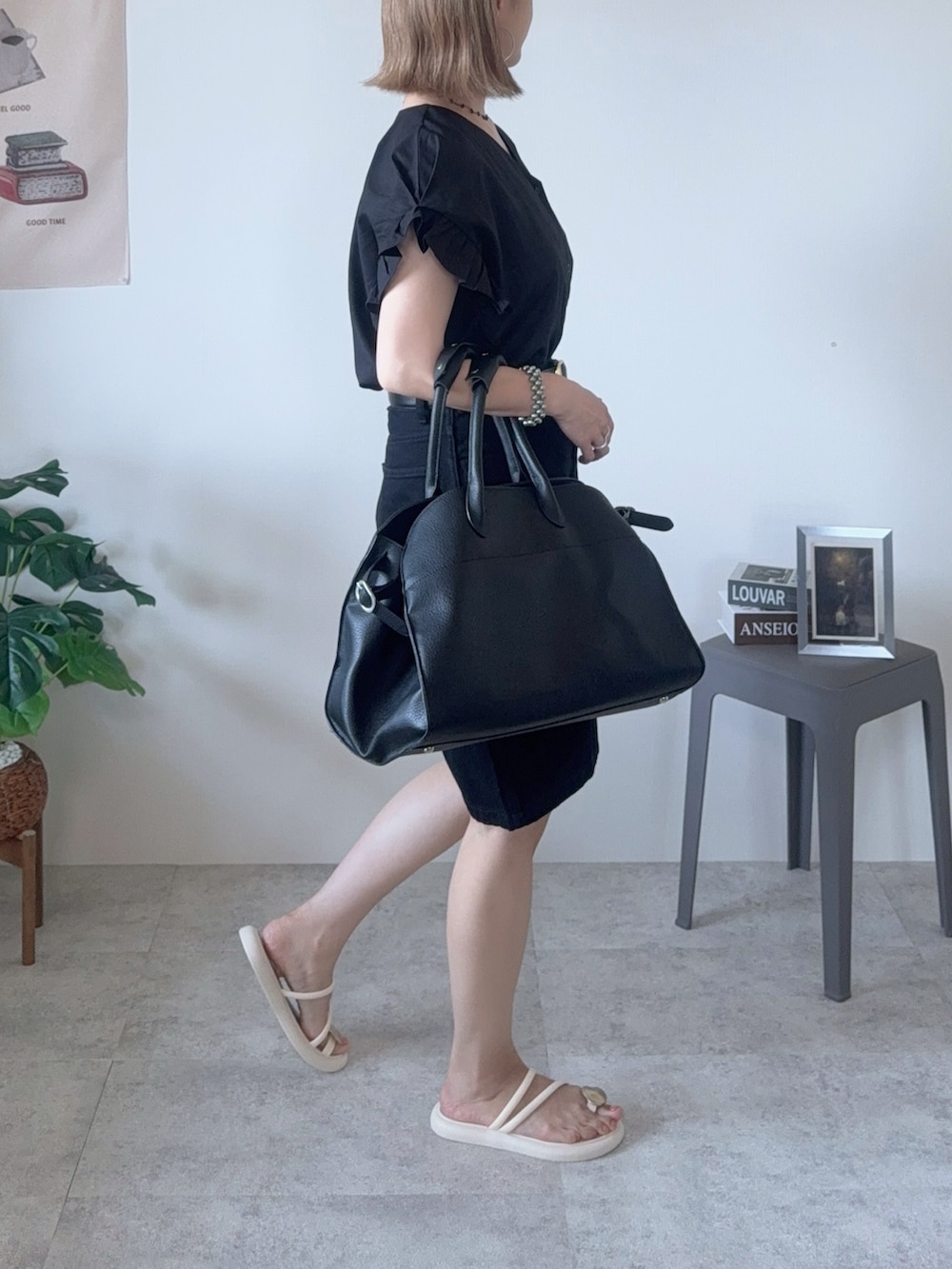 ブラック系のシャツ/ブラウス、ブラック系のボストンバッグ、ホワイト系のサンダルを着用したレディースの夏コーディネートの3枚目の写真