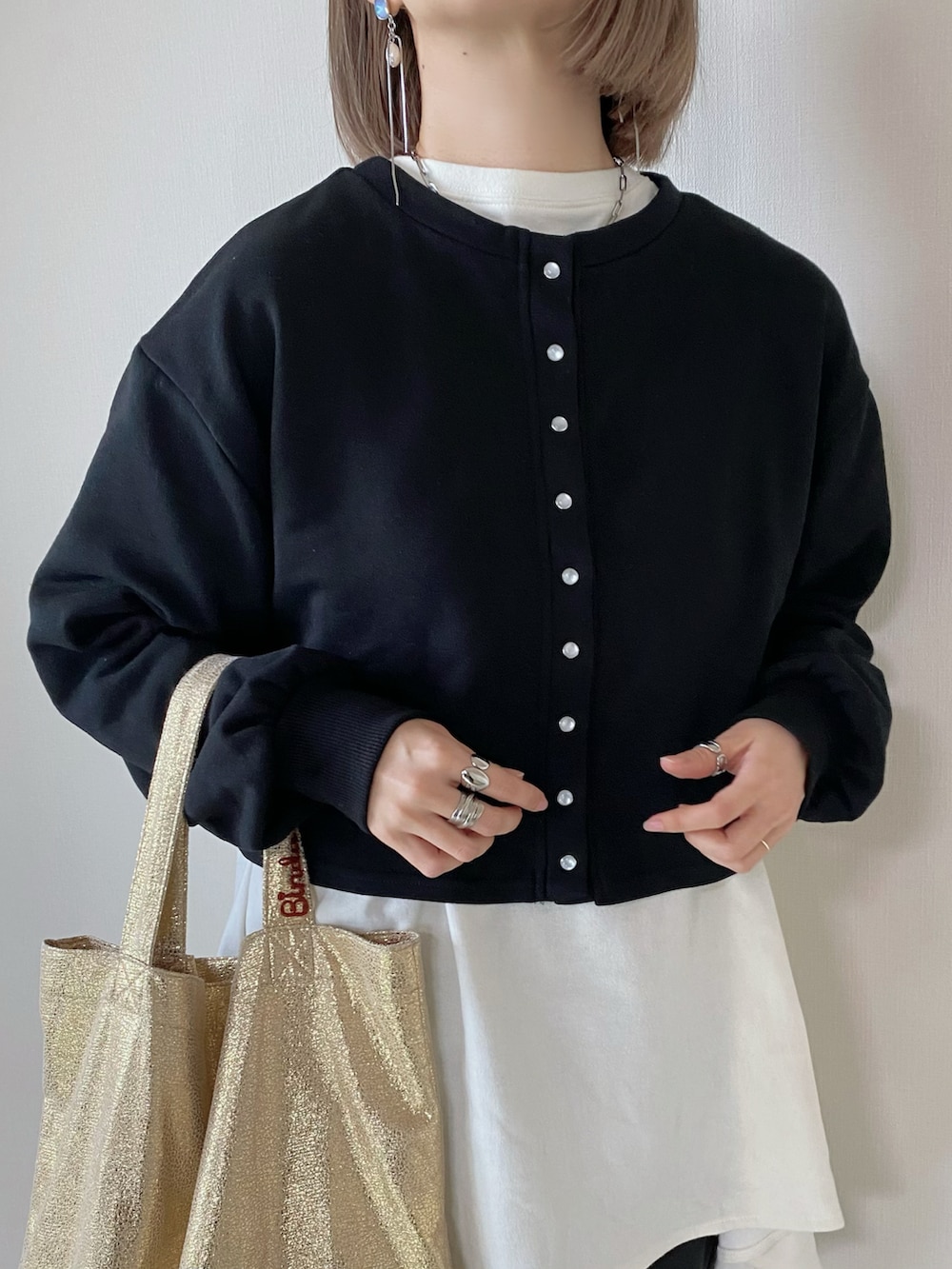 ブラック系のカーディガン/ボレロ、ホワイト系のTシャツ/カットソー、ブラック系のスラックスを着用したレディースの冬コーディネートの5枚目の写真