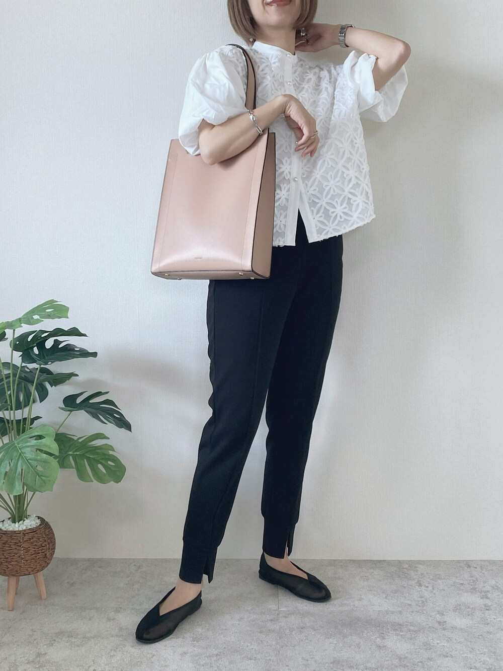 ピンク系のトートバッグ、ブラック系のパンツ、ブラック系のバレエシューズを着用したレディースの秋コーディネートの2枚目の写真
