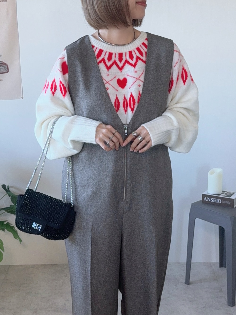 ブラック系のクラッチバッグ、ブラウン系のつなぎ/オールインワン、ホワイト系のブーツを着用したレディースの冬コーディネートの3枚目の写真