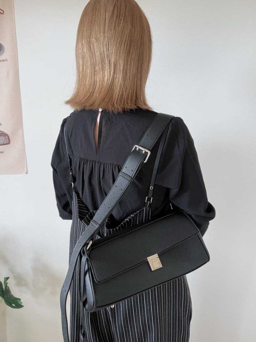 ブラック系のブーツ、ブラック系のシャツ/ブラウス、ブラック系のショルダーバッグを着用したレディースの秋コーディネートの5枚目の写真