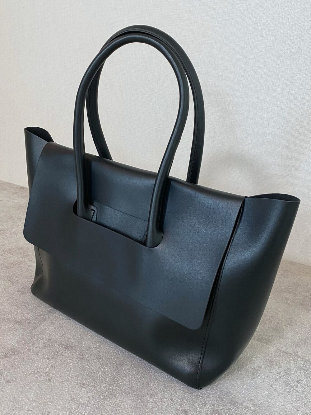 ブラック系のボストンバッグ、ホワイト系のシャツ/ブラウス、ブラウン系のローファーを着用したレディースの秋コーディネートの5枚目の写真