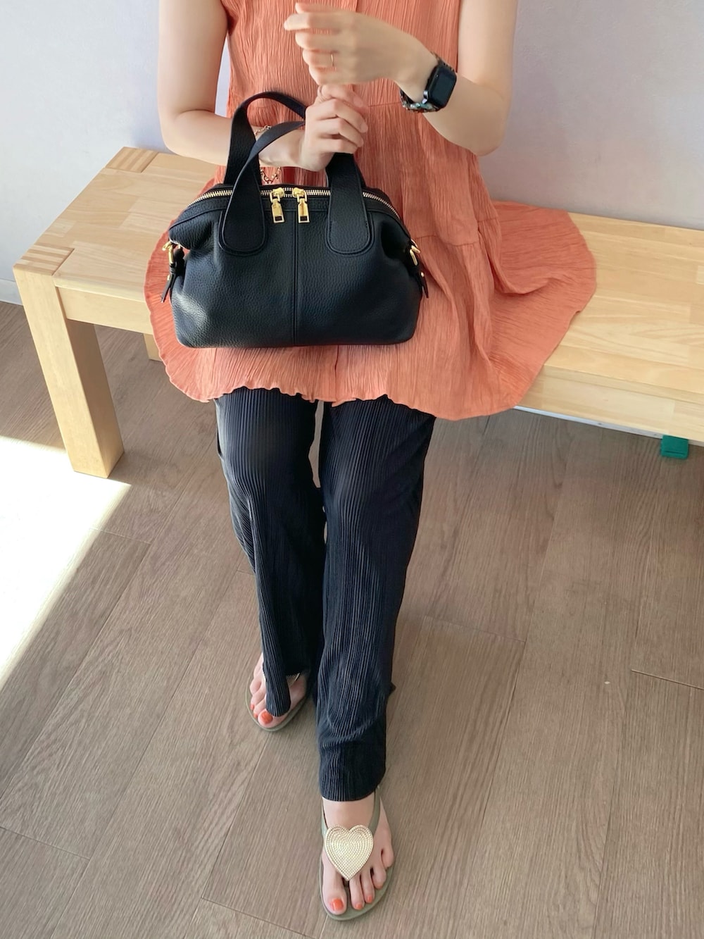 オレンジ系のシャツ/ブラウス、ブラック系のバッグ、ブラック系のその他パンツを着用したレディースの夏コーディネートの2枚目の写真