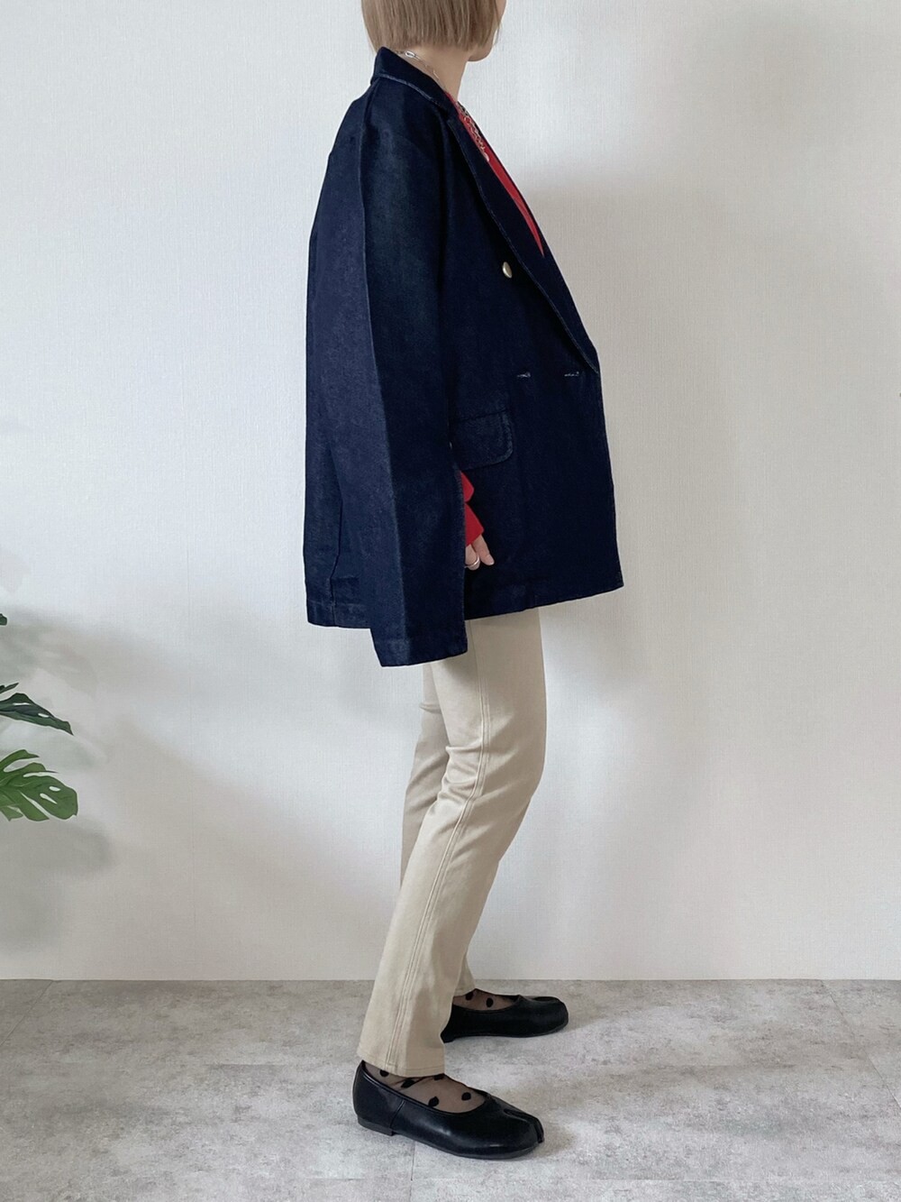 レッド系のスウェット、ブルー系のデニムジャケット、ブラック系のパンプスを着用したレディースの春コーディネートの5枚目の写真