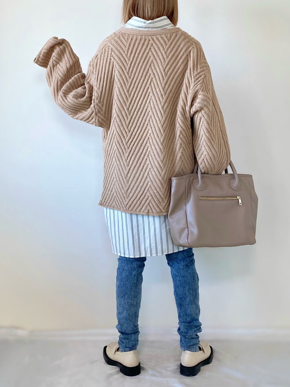 ベージュ系のニット/セーター、ホワイト系のシャツ/ブラウス、ベージュ系のバッグを着用したレディースの冬コーディネートの4枚目の写真