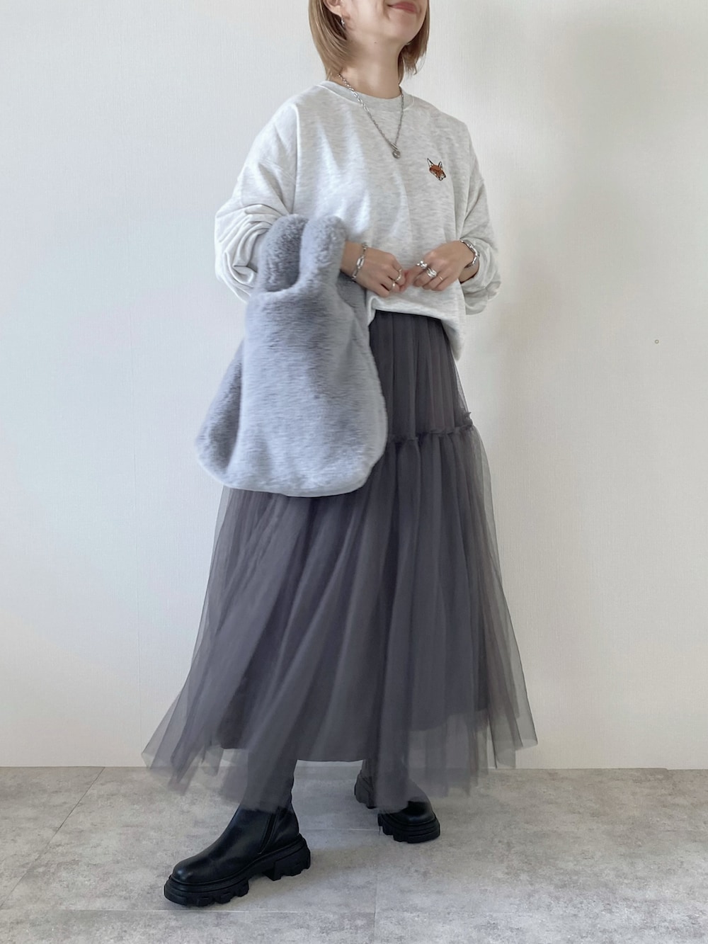 グレー系のスカート、ベージュ系のスウェットを着用したレディースの秋コーディネートの2枚目の写真