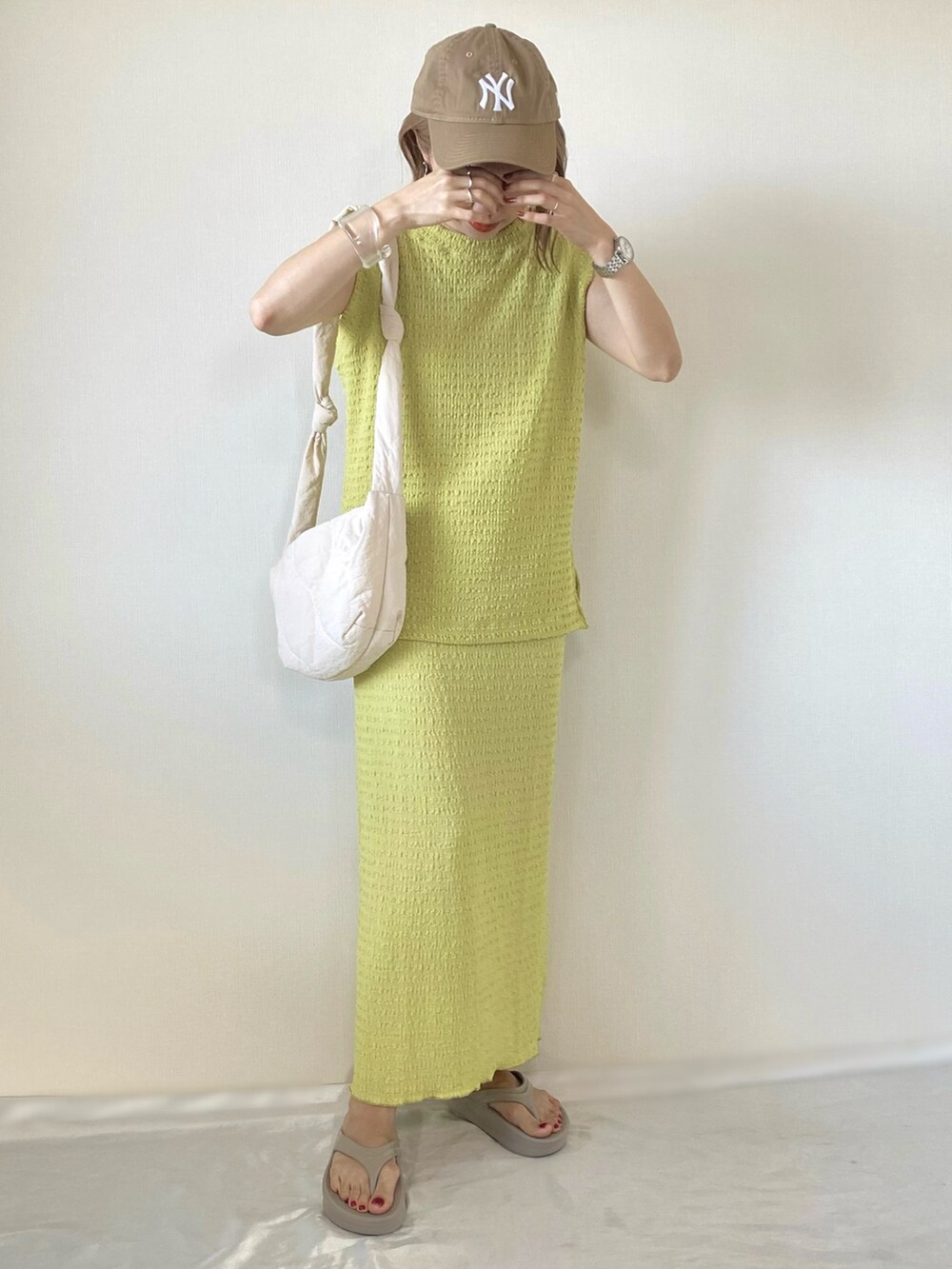 グリーン系のスカート、グリーン系のTシャツ/カットソー、ベージュ系のサンダルを着用したレディースの春コーディネートの3枚目の写真