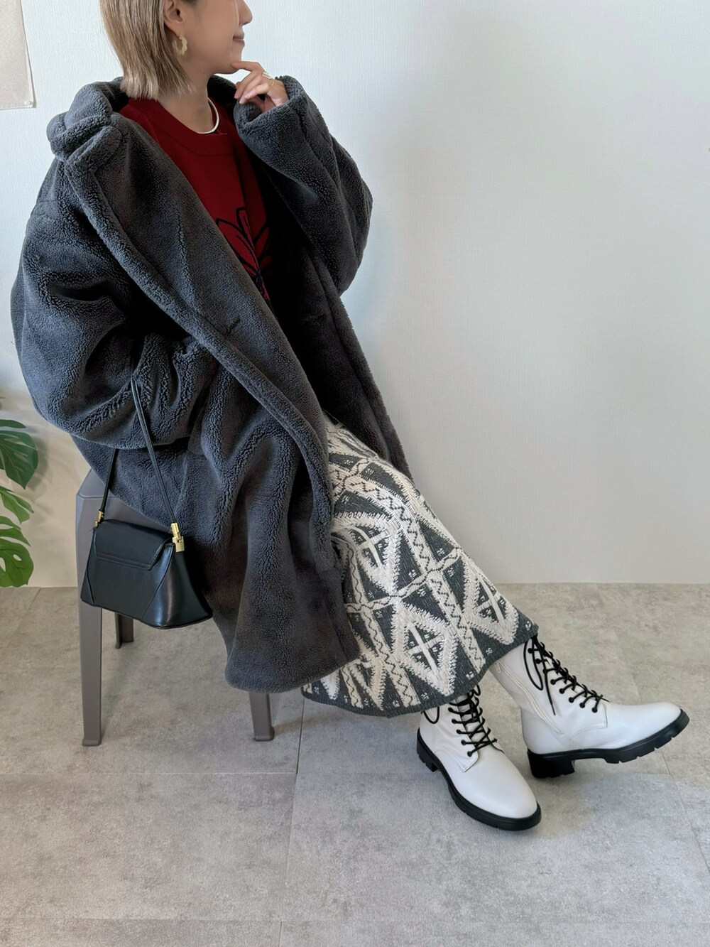 グレー系のピーコート、ブラック系のハンドバッグ、グレー系のスカートを着用したレディースの冬コーディネートの4枚目の写真