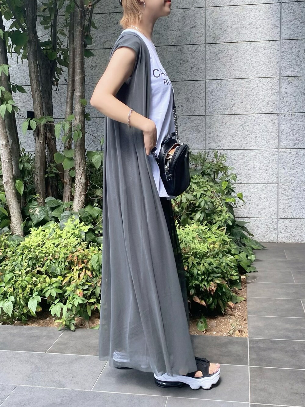 ブラック系のパンツ、ホワイト系のタンクトップ、ブラック系のサンダルを着用したレディースの秋コーディネートの2枚目の写真