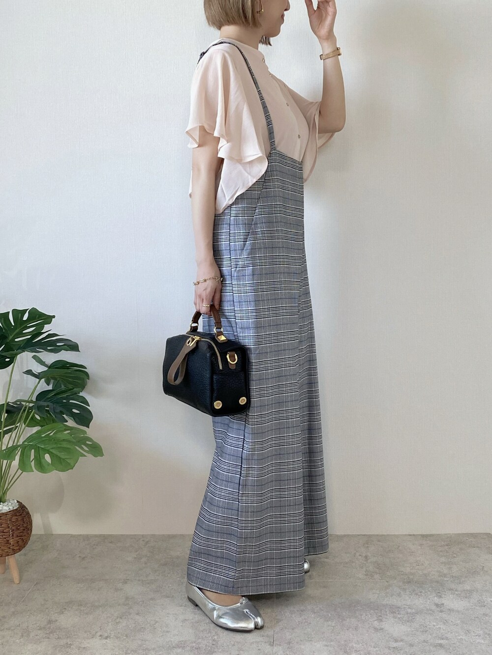 ブラック系のボストンバッグ、シルバー系のバレエシューズ、ピンク系のシャツ/ブラウスを着用したレディースの春コーディネートの2枚目の写真