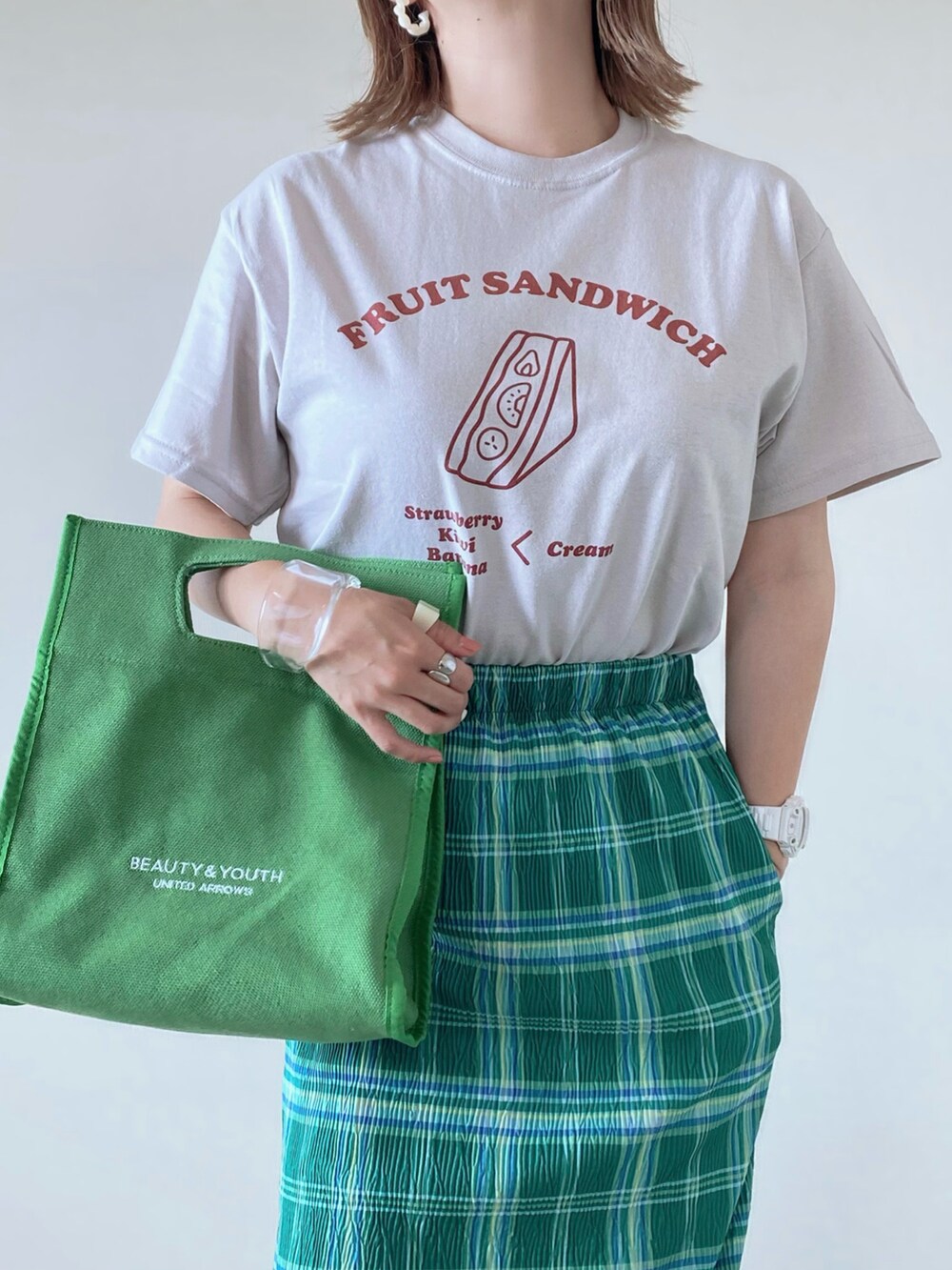 その他のTシャツ/カットソー、グリーン系のトートバッグ、グリーン系のスカートを着用したレディースの夏コーディネートの2枚目の写真