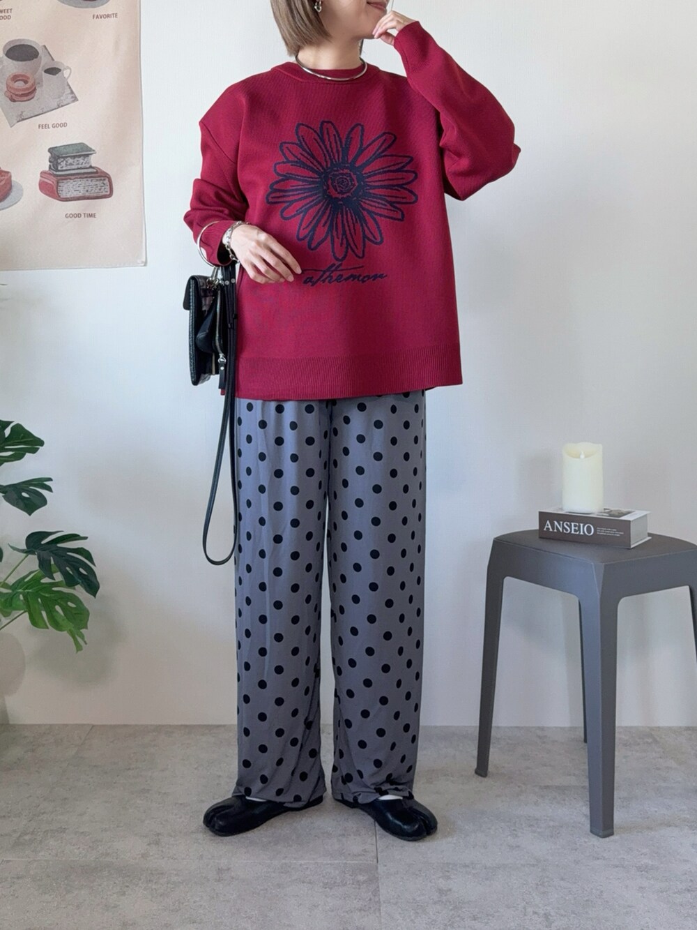 グレー系のパンツ、ブラック系のパンプス、シルバー系のネックレスを着用したレディースの秋コーディネートの2枚目の写真