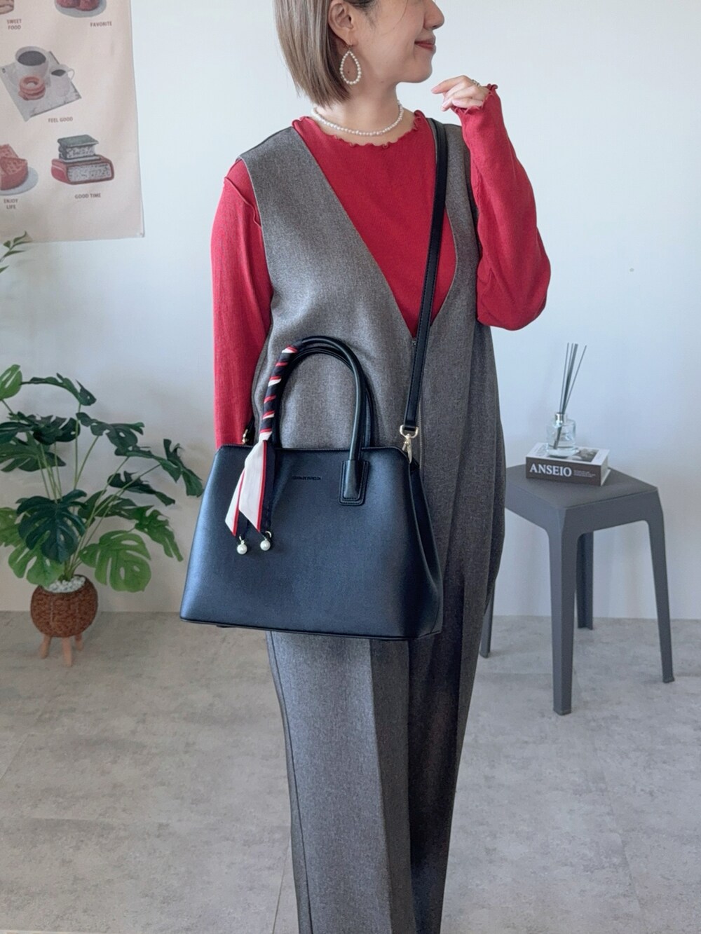 ブラック系のハンドバッグ、ブラウン系のつなぎ/オールインワン、ホワイト系のパンプスを着用したレディースの冬コーディネートの5枚目の写真