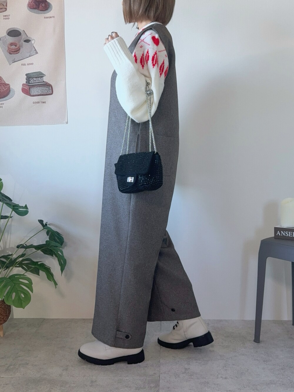 ブラック系のクラッチバッグ、ブラウン系のつなぎ/オールインワン、ホワイト系のブーツを着用したレディースの冬コーディネートの2枚目の写真