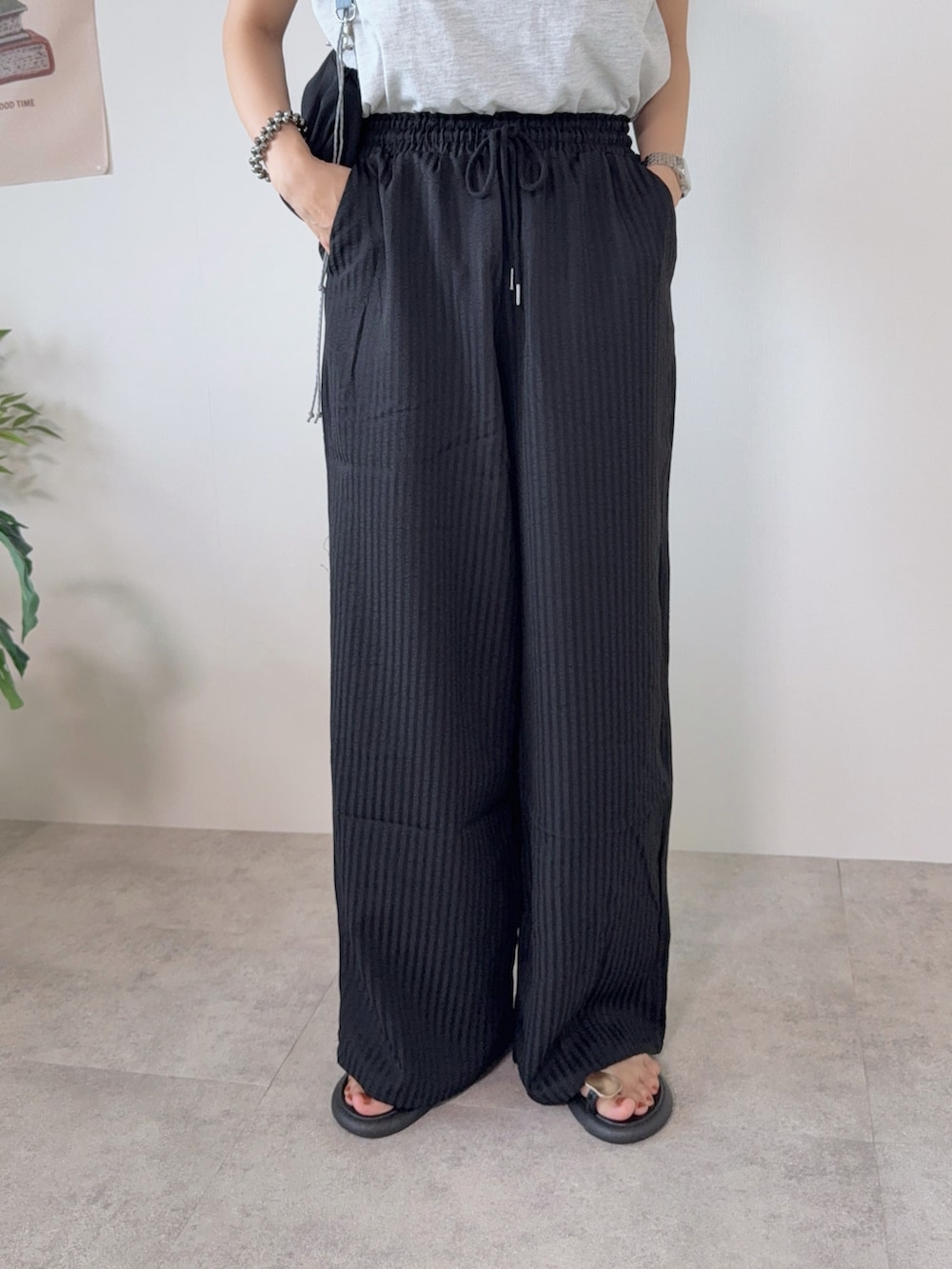 ブラック系のショルダーバッグ、ブラック系のその他パンツ、グレー系のTシャツ/カットソーを着用したレディースの夏コーディネートの4枚目の写真