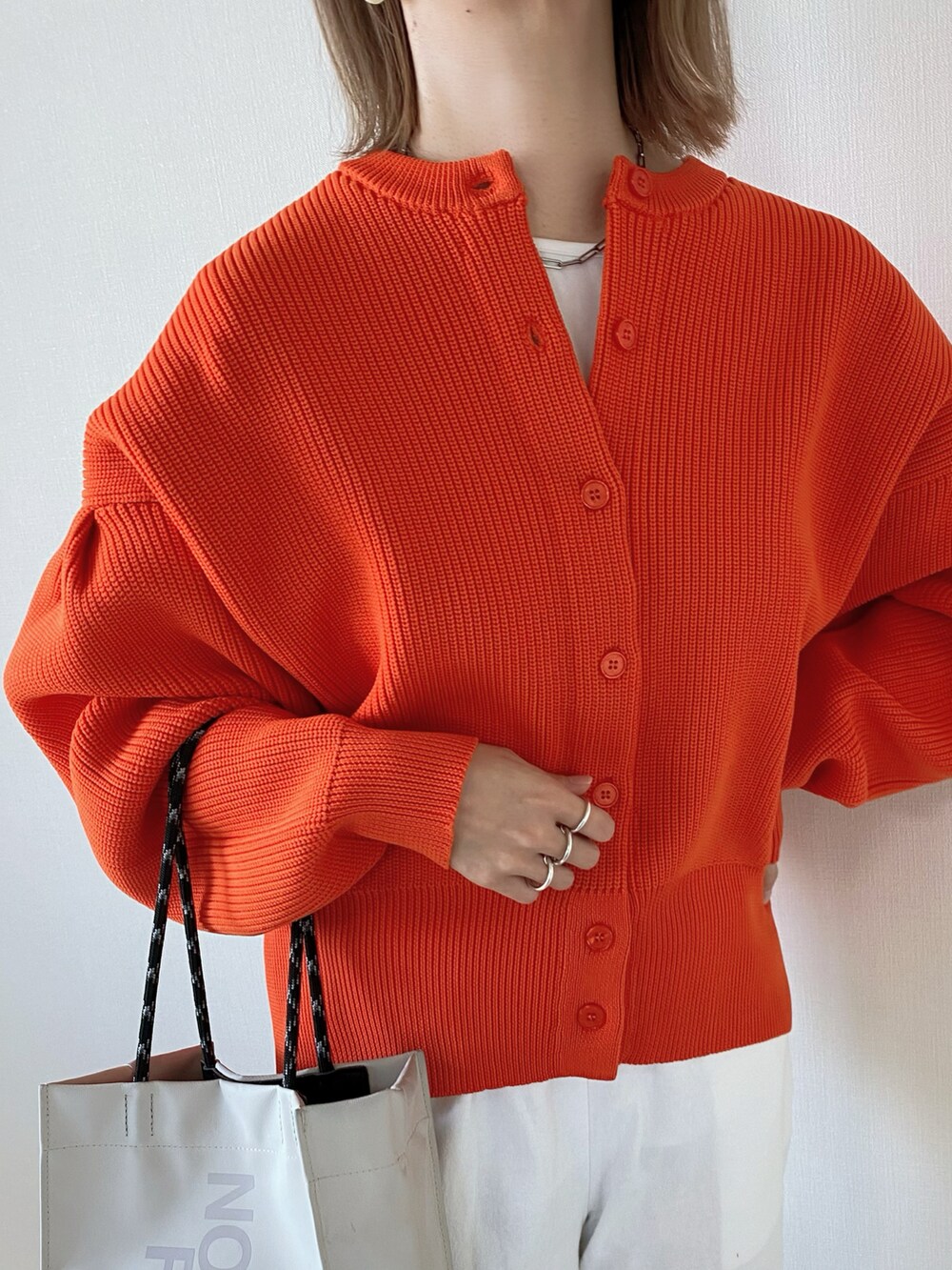 オレンジ系のカーディガン/ボレロ、ホワイト系のその他パンツ、ベージュ系のトートバッグを着用したレディースの春コーディネートの4枚目の写真